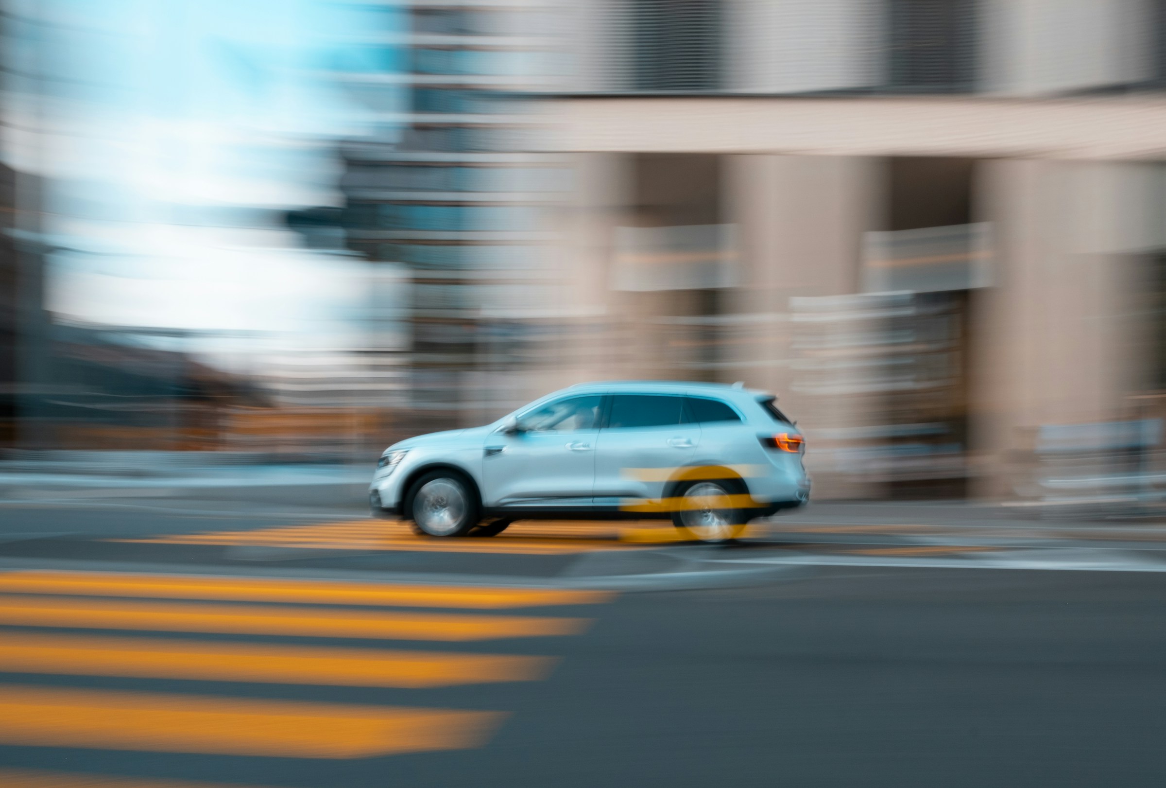 Motion-blurred car speeding through a city street, representing fast page load times